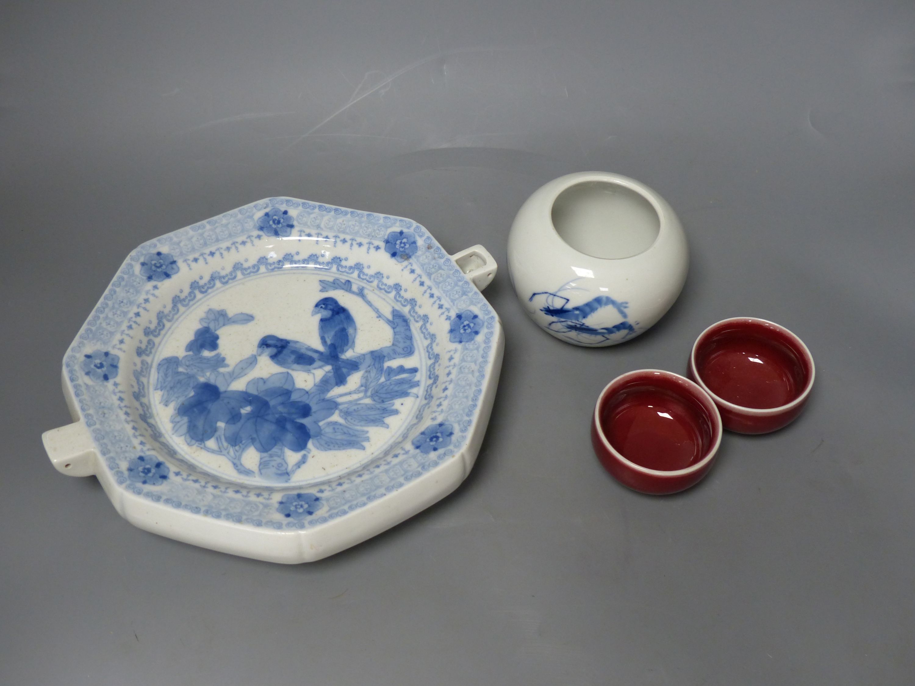 A Chinese blue and white water pot and two sang de boeuf cups and a plate warmer